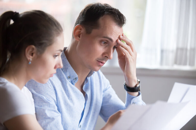 A man and woman reviewing documents together at a table.